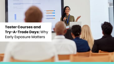 A woman stands at the front of a classroom giving a presentation to seated attendees, with a screen displaying charts and the title 